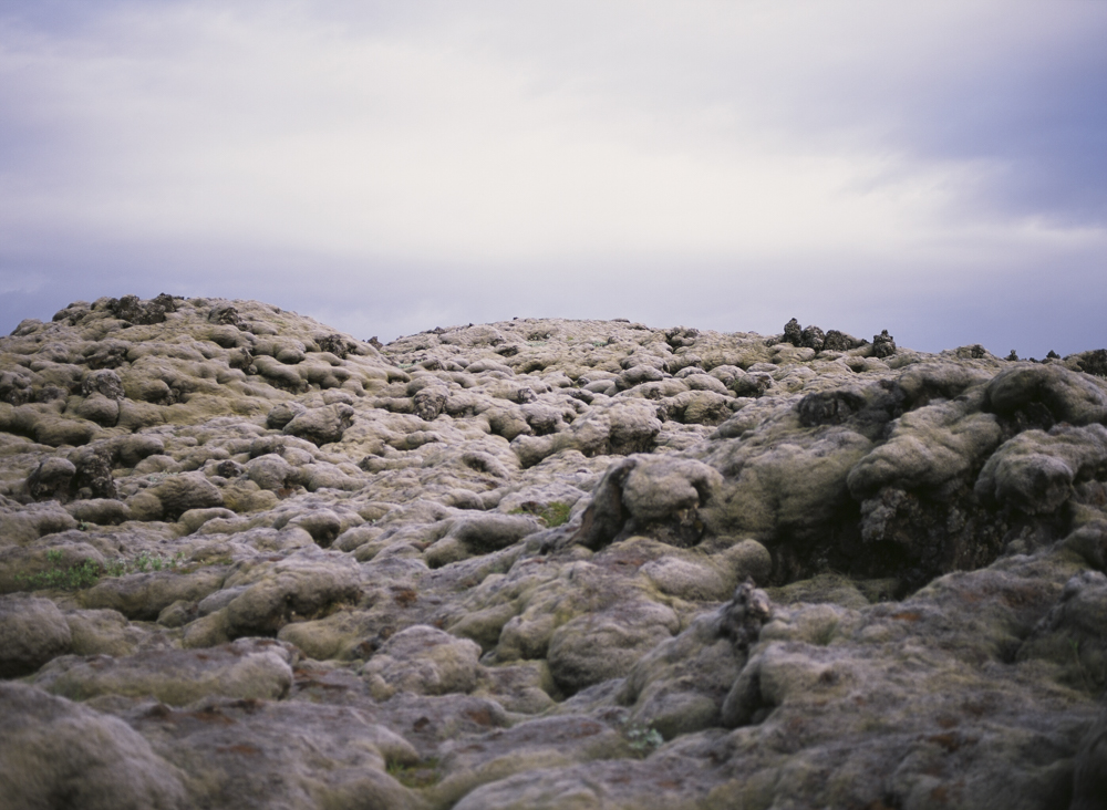 Close-up of moss-covered lava rocks in Eldhraun, Iceland, showing the lumpy texture of the ancient lava field under overcast skies.